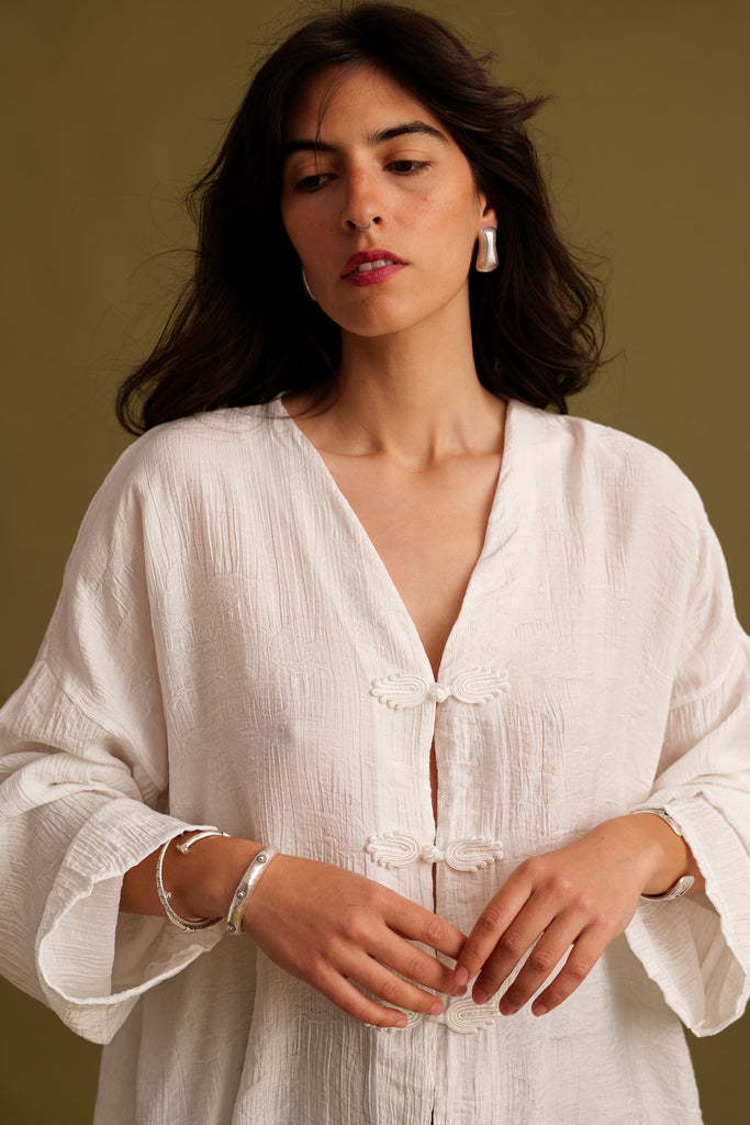 Soline Top — White textured top with frog closures, on model — MYFASHIONFRUIT