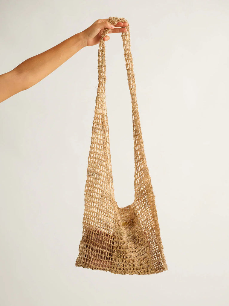 Uttara Shoulder Bag — Woven tote bag in tan held by hand — MYFASHIONFRUIT