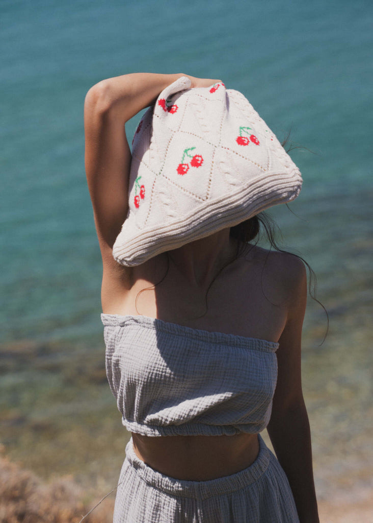 Cerise Crochet Bag — Model holding bag over head outdoors — MYFASHIONFRUIT