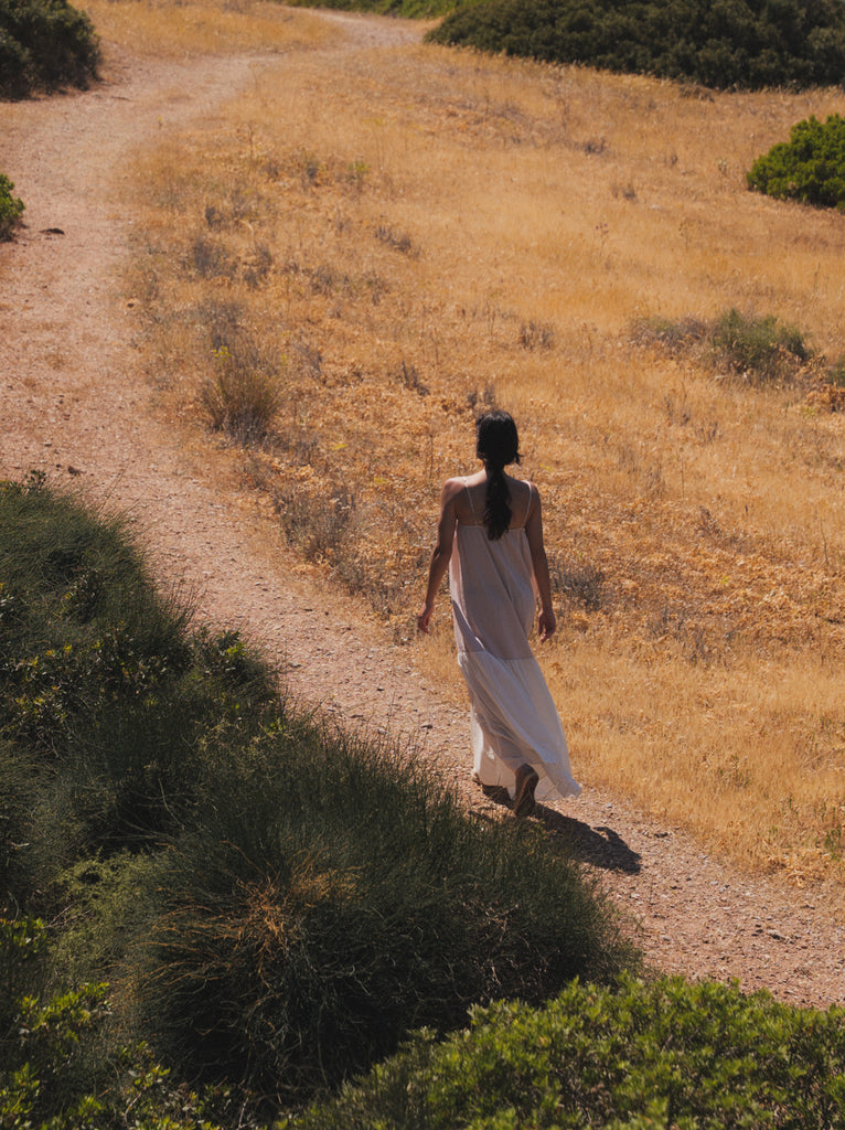 Brooklyn Dress — White maxi dress on model walking on a path — MYFASHIONFRUIT