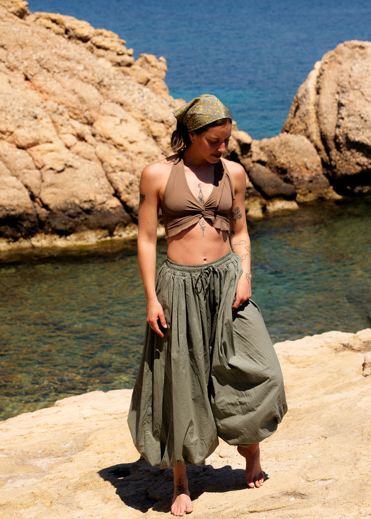 Sol Balloon Pants — Olive green balloon pants, model on the rocks — MYFASHIONFRUIT