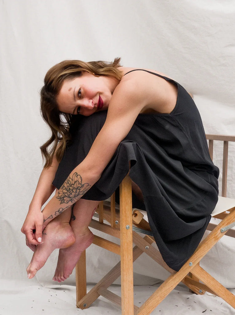 Granadas Dress — Black slip dress on model sitting on chair — MYFASHIONFRUIT